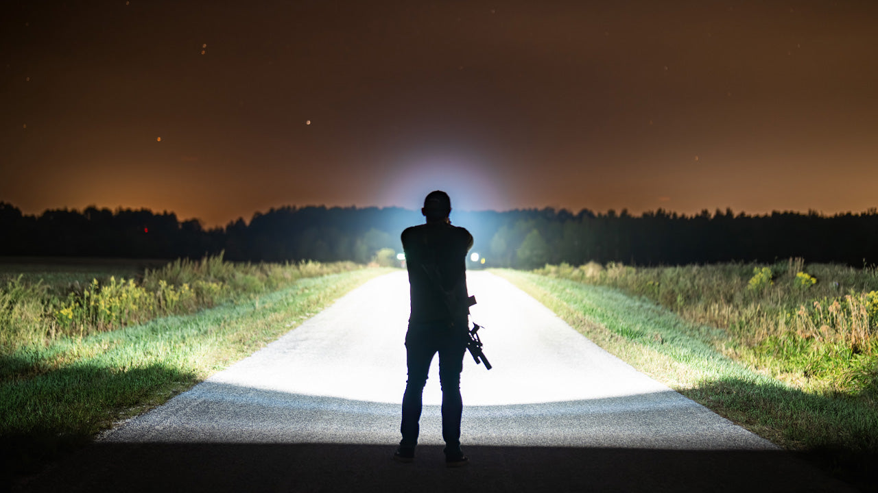 A image with a person facing away using a flashlight