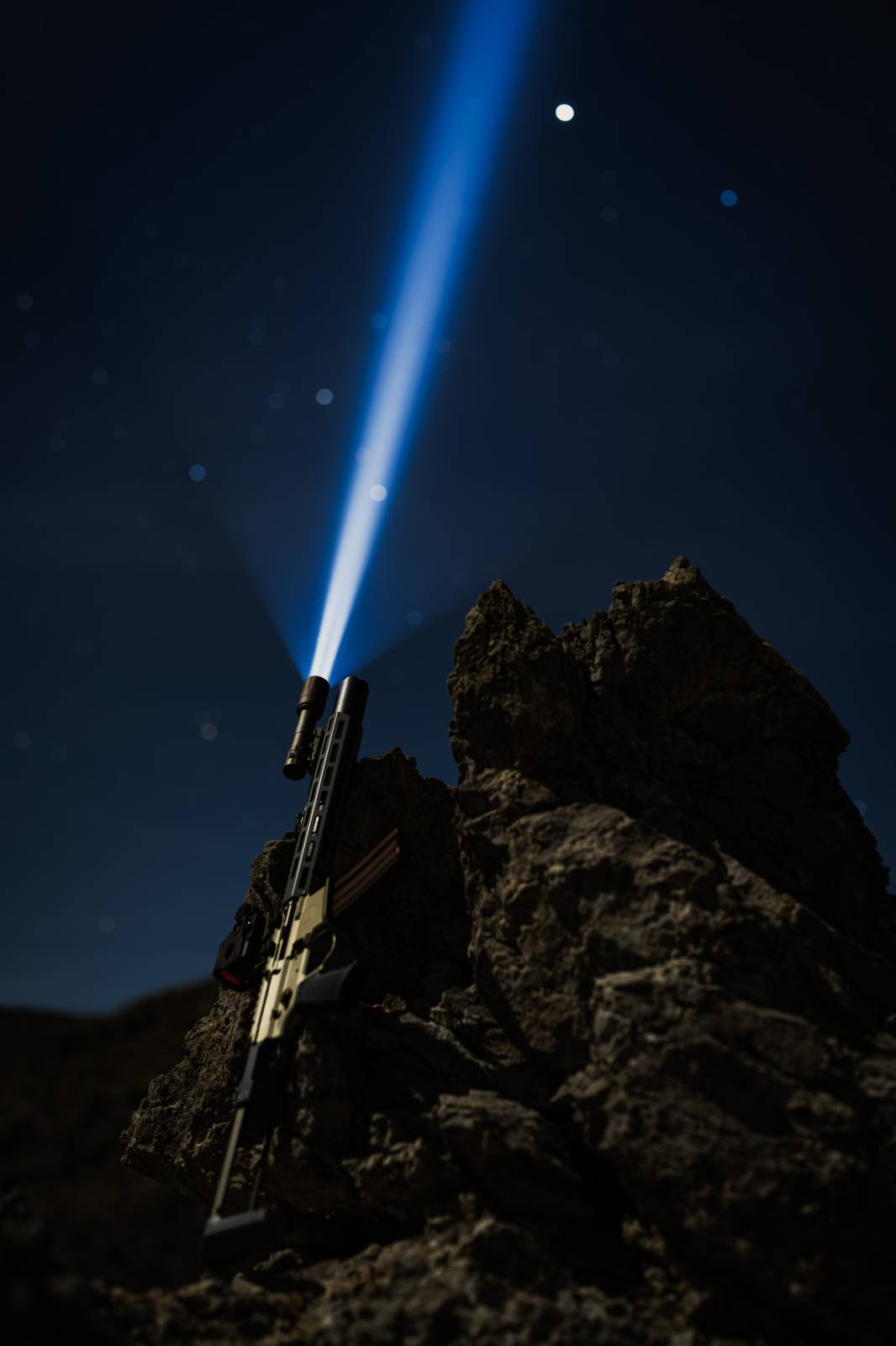 Honey badger rifle with Rein flashlight shining into night sky