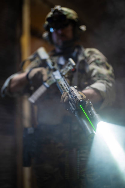 Military member holding rifle with Rein flashlight and laser aiming module. 